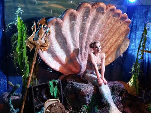 Undersea theme props for rent, giant clam shell and coral for mermaid to sit in shown here with a mermaid on the shell during a party
