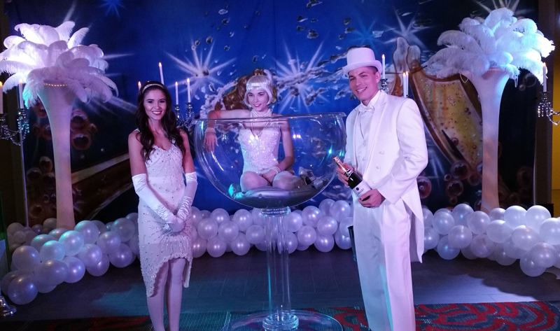 New Years Eve entertainers, two girls in beaded costumes in a giant champagne glass